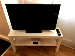 レーゲンスブルクにあるApartment Flowersideの白いテーブルの上に置かれたリモコン付きのテレビ