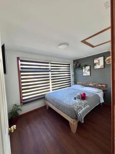 a bedroom with a bed and a large window at Oro y Miel in Callaqui