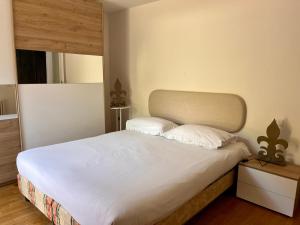 a bedroom with a bed with white sheets and pillows at Vicolo Carate in Gravedona