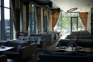 a dining room with couches and tables and windows at GirSki in Bukovel