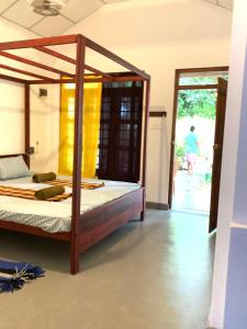 a bedroom with a bed with a wooden frame at Vinka Place Arugambay in Arugam Bay