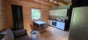a kitchen and living room with a table and a stove at Leśne Zacisze 3 in Łuka +8 photos