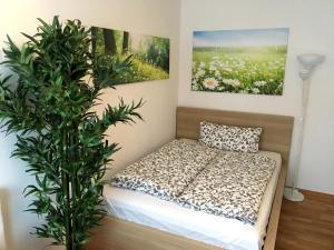 a bed in a room with a plant next to it at Apartment Flowerside in Regensburg