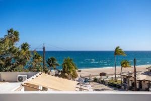 a view of a beach with palm trees and the ocean at Casa Girasol Ocean Views Steps to Beach in Buenavista