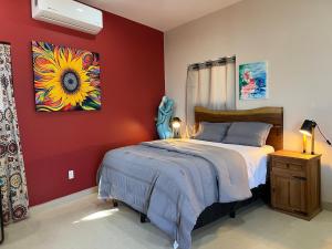 a bedroom with a bed and a painting on the wall at Casa Girasol Ocean Views Steps to Beach in Buenavista