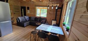 a living room with a couch and a table and chairs at Leśne Zacisze 3 in Łuka