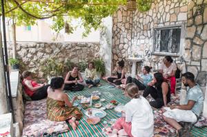 a group of people sitting on the ground in a courtyard at Beit Al Baraka in Um Qeis