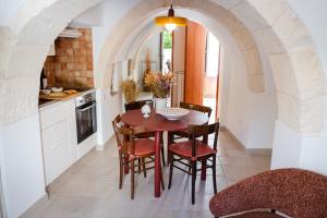 a kitchen with a table and chairs in a room at Trullo Màufra in Locorotondo +23 photos