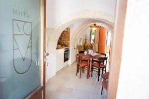 a kitchen and dining room with a table and chairs at Trullo Màufra in Locorotondo