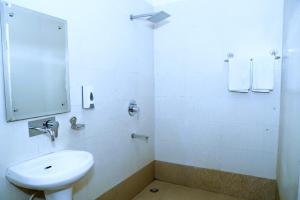 a white bathroom with a sink and a mirror at Hotel SP Grand Near Mohali Bus Stand & Civil Hospital in Mohali
