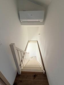 a staircase in a white room with a ceiling at Grange 4 couchages in Mios