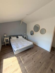 a bedroom with a bed and three mirrors on the wall at Grange 4 couchages in Mios
