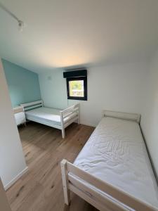 a bedroom with two beds and a window at Grange 4 couchages in Mios