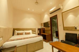 a bedroom with a bed and a desk and a mirror at Jullundur Hotel & Restaurant in Chandīgarh
