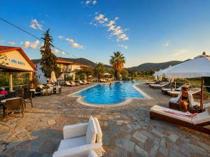 a pool at a resort with white lounge chairs at Annamaria Studios & Apartments in Petra