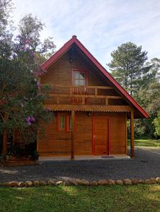 a log cabin with a red door at Cabana mandaçaia in Timbe do Sul