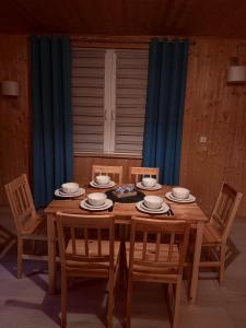 a wooden table with chairs and plates on it at Domek na Mazurach - nad jeziorem Dadaj in Wilimy