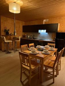 a wooden dining room table with chairs and a kitchen at Domek na Mazurach - nad jeziorem Dadaj in Wilimy