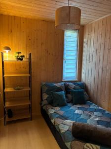 a bedroom with a bed in a room with wooden walls at Domek na Mazurach - nad jeziorem Dadaj in Wilimy