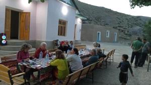 a group of people sitting at a long table at Asraf village guesthouse in Aydar Kul’