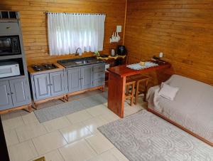 a kitchen with a sink and a table in a room at Cabana mandaçaia in Timbe do Sul