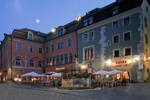 a large building with tables and chairs in front of it at Hotel Kaiserhof am Dom in Regensburg