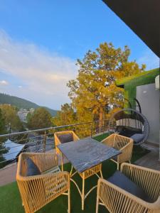 a patio with a table and chairs on a balcony at The Crib, Murree Hills in Lower Topa