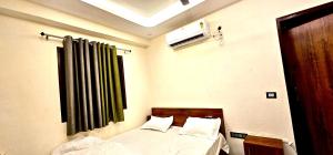 a bedroom with a bed with a green curtain at Hotel Sangree in Jewar