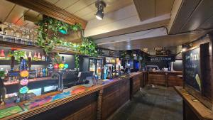 a bar with a long counter with a lot of alcohol at The Ship Inn Looe in Looe
