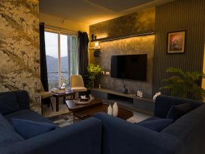 a living room with a blue couch and a television at The Crib, Murree Hills in Lower Topa