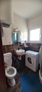 a bathroom with a toilet a sink and a washing machine at Emma 2 in Budva +14 photos
