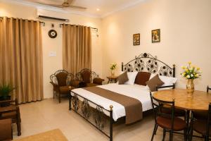a bedroom with a bed and a table and chairs at Central Hotel in Lucknow