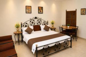 a bedroom with a bed and a table and chairs at Central Hotel in Lucknow