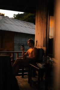a man sitting in a chair on a porch at Nuttonton Homes in Papas +1 photo