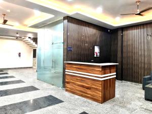 a lobby with a wooden counter and a glass wall at Hotel Sangree in Jewar