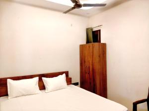 a bedroom with a bed and a ceiling fan at Hotel Sangree in Jewar +19 photos