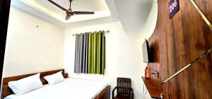 a bedroom with a bed and a green curtain at Hotel Sangree in Jewar