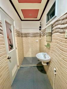 a bathroom with a toilet and a sink at Tipsy Bay Inn - Malapascua in Daanbantayan