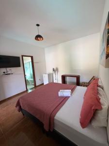 a bedroom with a large bed with a red blanket at Estadia Cipó Pousada & Piscina in Serra do Cipo +64 photos