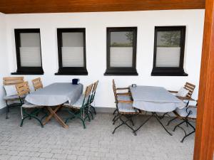 a patio with two tables and chairs and windows at Pension Pohl in Wenden