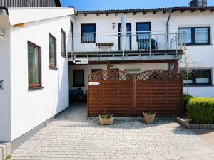 a house with a wooden gate and a balcony at Pension Pohl in Wenden
