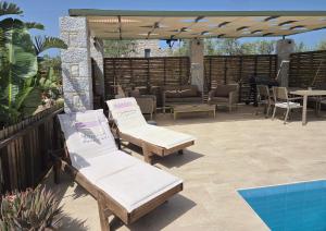 eine Terrasse mit Stühlen und einem Tisch sowie ein Pool in der Unterkunft Spitiko Mas in Riglia