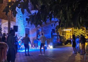 Eine Gruppe von Menschen steht nachts auf der Straße. in der Unterkunft Spitiko Mas in Riglia + 32 Fotos