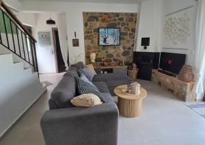 ein Wohnzimmer mit Sofa und Tisch in der Unterkunft Spitiko Mas in Riglia