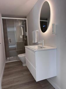 a bathroom with a sink and a toilet and a mirror at Urania Cadiz Apartments by Soho Boutique in Cádiz +97 photos