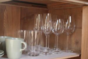 a row of wine glasses sitting on a shelf at FreiLAND-Häusle in Weikersheim