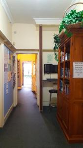 a hallway of an office with a book shelf at Rucksacker Backpacker Hostel in Christchurch