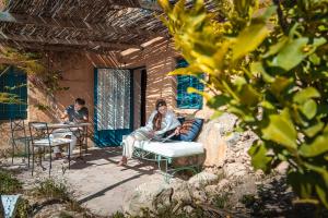 a woman sitting on a bench on a patio at Beit Al Fannan in Ţabaqat Faḩl