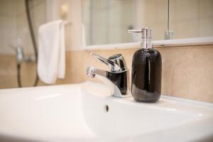 a bathroom sink with a black soap dispenser on it at Apartments Fabijanić in Rab +74 photos