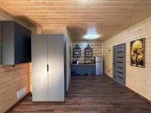 a hallway in a house with a kitchen and a room with wooden walls at Шервуд in Myta
